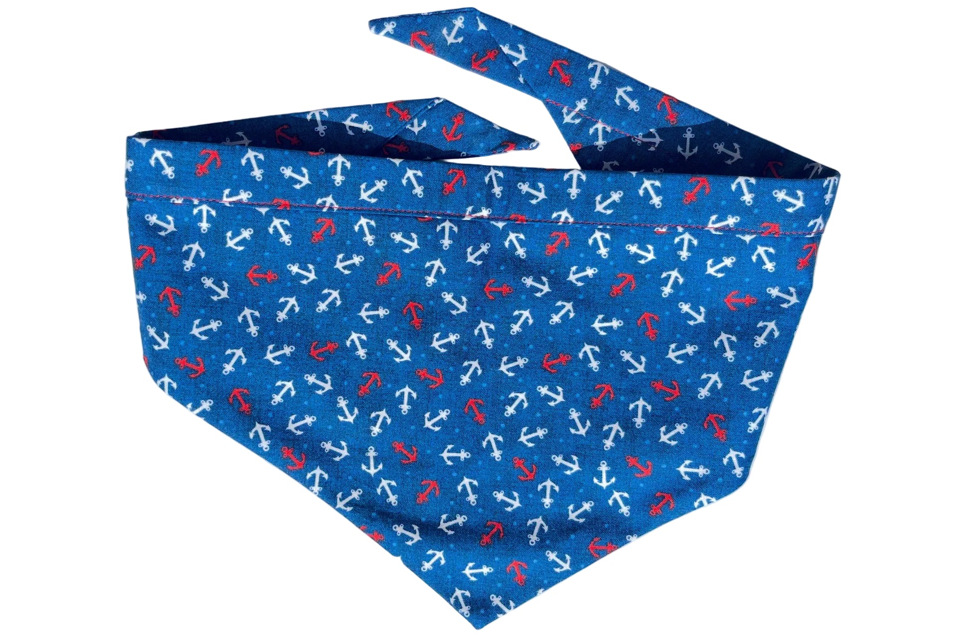 Dog bandana with pattern of red and white anchors on blue background